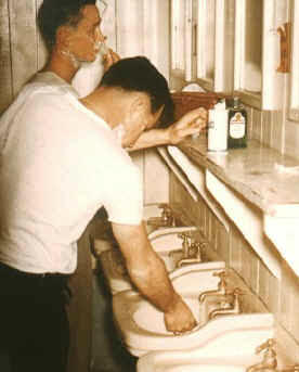 Two friends shaving in barracks at camp